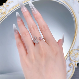 Detail of 925 silver ring featuring pink teardrop stone and leaf pattern on finger