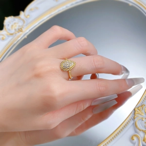 Dettaglio macro dell'anello a goccia dorato con pietre pavé e fascia ritorta chic