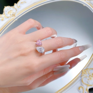 Macro detail of Toi et Moi ring featuring pink heart and white pear cut stones
