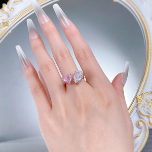 Detail of a silver open ring with pear-cut white diamond and heart-shaped pink stone
