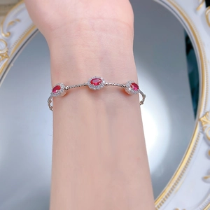 Detail of S925 silver bracelet with red rubellite stones and rope texture on a model's wrist
