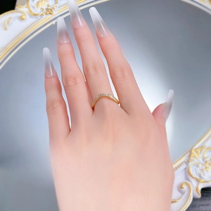 Macro shot of V-shaped gold ring with pavé-set stones on an elegant vintage background