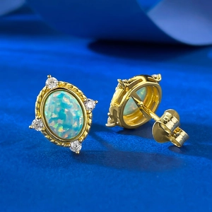 Detailed macro view of oval blue opal earrings with gold plating and rope texture detail