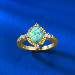Detailed macro of vintage gold opal ring with blue-green play-of-color and side diamonds