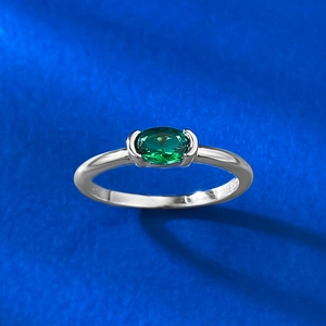 Vista macro di una gemma verde ovale incastonata in un anello in argento 925 minimalista