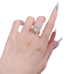 Elegant gold oval cut engagement ring with double-layered wavy band on model hand