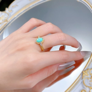 Detailed close-up of S925 gilded opal ring with blue oval stone and marquise accents