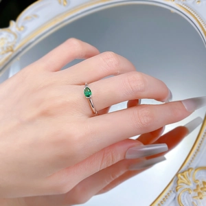 Dettaglio di un anello in argento S925 con gemma verde ovale e castone a griffe classico