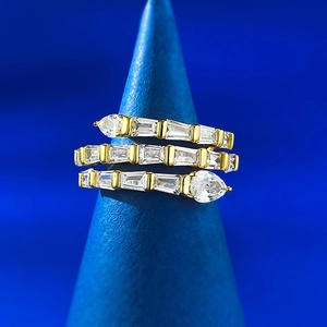 Détail macro d'une bague serpent dorée à plusieurs rangs sertie de zircons cubiques brillants