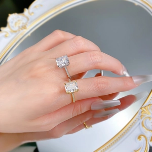Detail of silver and gold radiant cut rings with pavé settings on a hand