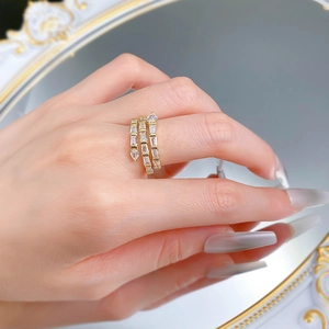 Détail d'une bague serpent triple rangée dorée avec zircons portée par un mannequin