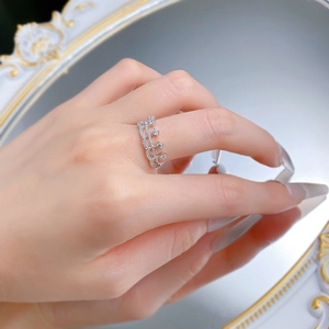 Detailed view of a silver crown ring with sparkling crystals on a vintage mirror surface