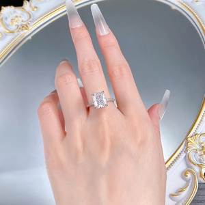 Detailed close-up of radiant cut 8x10mm gemstone ring with pavé diamonds on finger