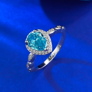 Macro shot of S925 silver ring featuring a pear-cut blue gemstone and halo diamonds