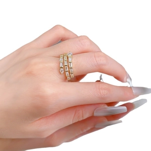 Bague serpent dorée multicouche sertie de diamants baguette et poire sur la main