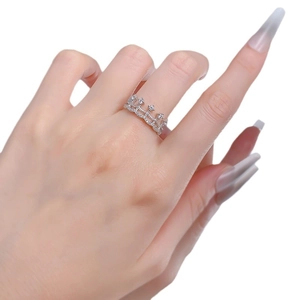 Sparkling silver crown lace ring with cubic zirconia on female hand over white background