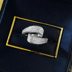 Close-up of S925 silver S-shaped crisscross ring with pavé zircons in a navy jewelry box