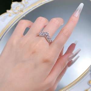 Macro detail of V-shaped crown ring with marquise-cut stones on a model's finger