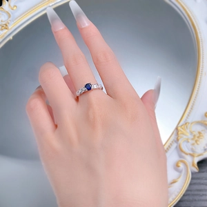 Detail shot of a S925 silver ring featuring an oval blue sapphire and side zircons
