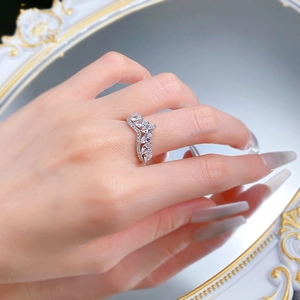Macro shot of V-shaped crown ring featuring marquise-cut stones on a mirror surface