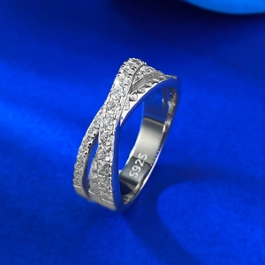 Detail of S925 sterling silver cross ring with pavé zircons on blue silk background