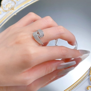Detail of S925 silver crossover ring with pave zircon stones shown on finger