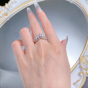Detail of V-shaped crown ring with marquise-cut zircons on a model's finger