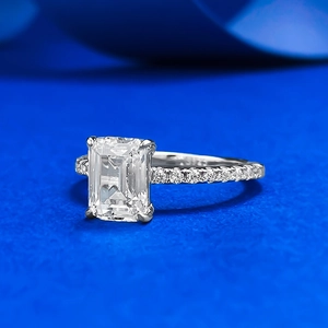 Macro side view of emerald-cut high carbon diamond ring with pavé-set silver band