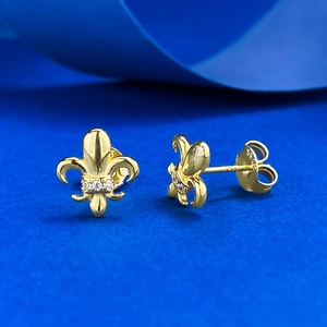 Detail of golden S925 silver iris earrings with zircon inlays on blue background