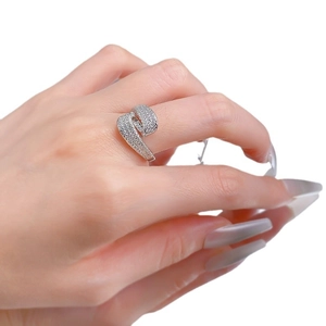 Luxurious S-shaped silver-tone ring with pavé-set zircons on a model's finger