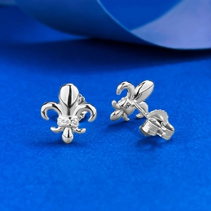 Close-up of S925 silver fleur-de-lis earrings with inlaid zircons on royal blue fabric