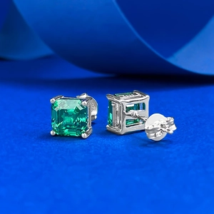 Close-up of S925 silver stud earrings with emerald-cut green stone and 925 hallmark
