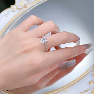 Close-up of emerald cut rectangle solitaire ring with pavé stones on S925 silver band