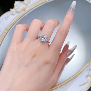 Detailansicht eines ovalen Halo-Silberrings mit Perlenrand an der Hand des Models