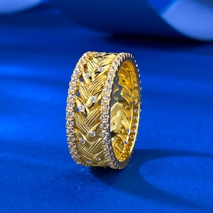 Golden wide wheat grain textured ring with sparkling zircon pavé edges on blue velvet