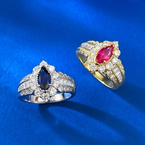 Macro shot of marquise sapphire and ruby rings in gold and silver with diamond clusters