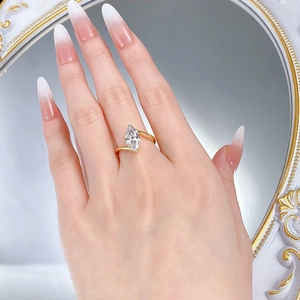 Detailed view of marquise cut diamond ring with crisscross gold band on model finger