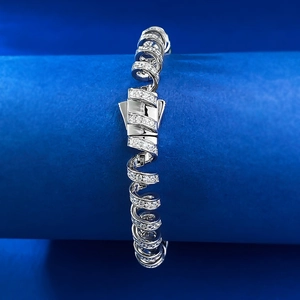 Détail d'un bracelet spirale en argent S925 serti de cristaux sur un support bleu