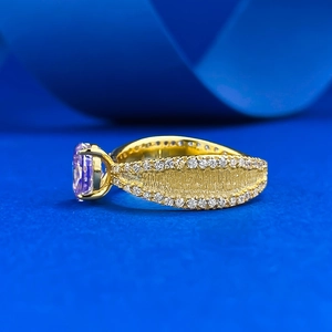 Vue latérale d'une bague dorée avec pierre lavande ovale et bordures pavées de zircons