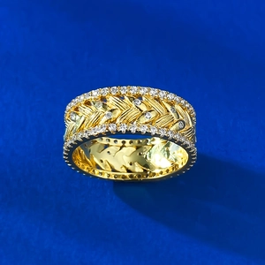 Detail of gold wheat ear ring with micro-pave crystals on blue background