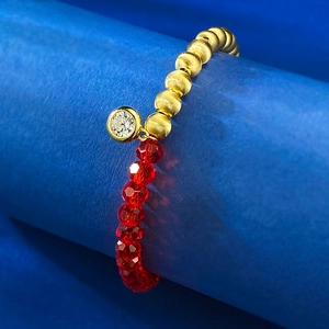 Gros plan sur les perles dorées et pierres rouges facettées du bracelet élégant S925