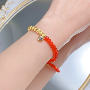 Bracelet élégant en argent S925 plaqué or avec perles œil de chat rouges sur un poignet
