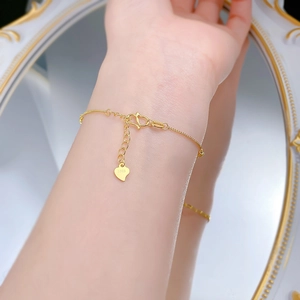 Detailed view of S925 heart pendant and gold chain on wrist with mirror background