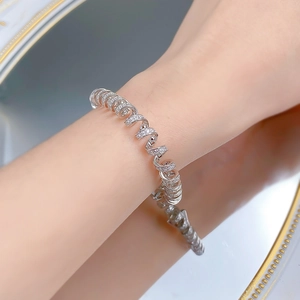 Détail macro du bracelet spirale étincelant en argent S925 porté au poignet