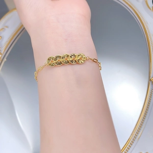 Detail of a gold Five Emperor Coins bracelet featuring intricate vintage hollow textures