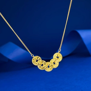 Macro shot of Five-Emperor coins gold pendant with laser-cut texture on blue silk fabric
