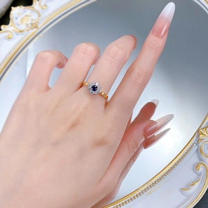 Detailed close-up of a blue sun flower ring with crystals on a vintage mirror surface