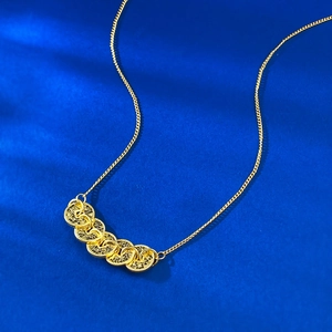 Gold-plated five coins necklace with radiating textured pendants on a deep blue background