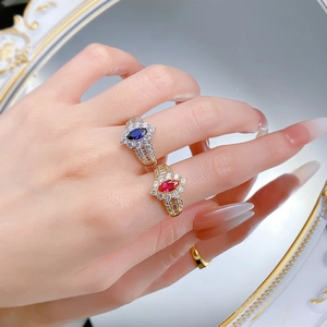 Vue macro de bagues en rubis et saphir taille marquise avec halo de diamants sur argent