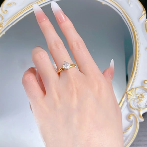 Detailed close-up of a princess cut white crystal ring on a model's hand with mirror reflection